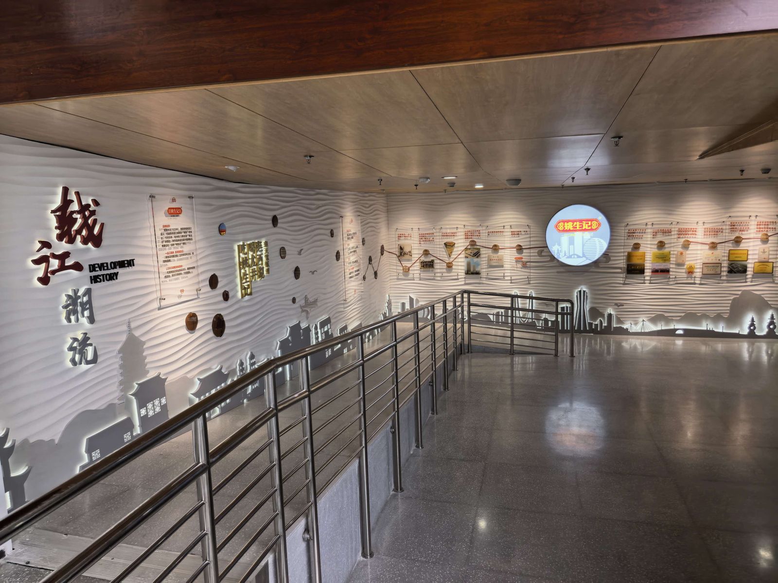 转上楼梯，「钱江潮涌」四个字立在波浪纹的墙面上，拐角处是姚生记的圆形标识灯箱。