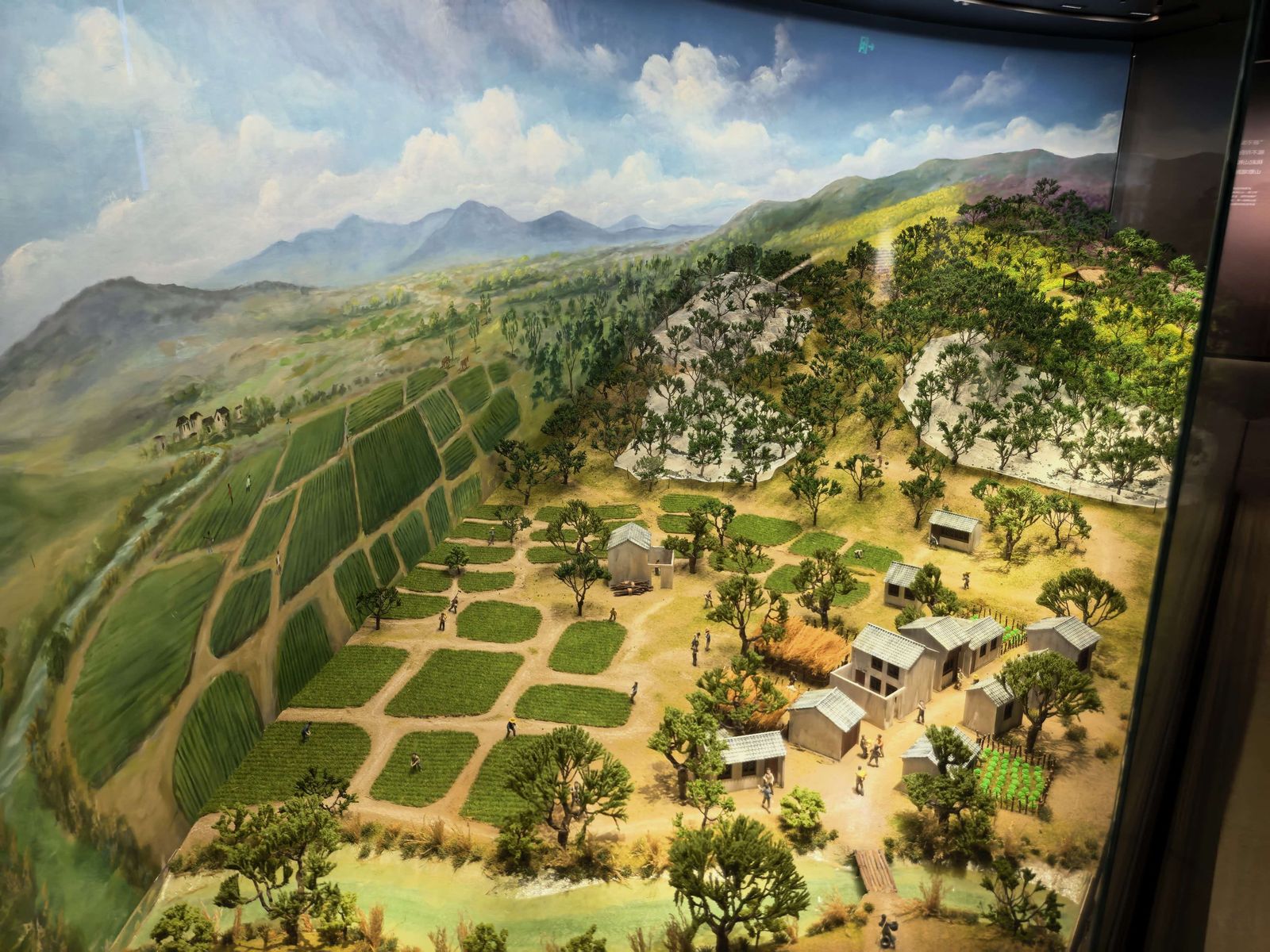 微缩沙盘复原了山核桃古法栽培的山地场景：层叠的梯田、林下的村落与耕作的人影。
